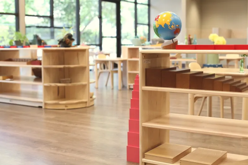 Low wooden shelves in a sunlit classroom